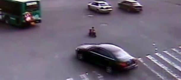 Chinese toddler rides scooter through intersection