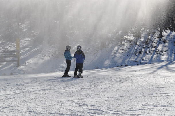 A pair of skiers wait at the bottom of the slopes 