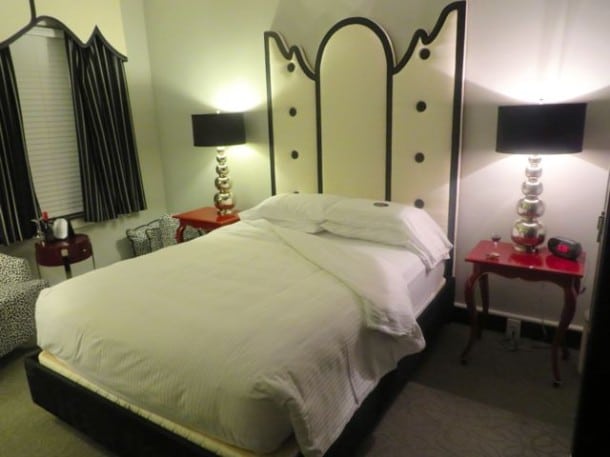 Unique and comfortable bed—with a nightcap of wine and chocolate on the end table—at the King’s Daughters Inn