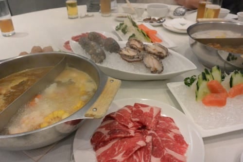 Meat, fish, veggies going into the hot pot