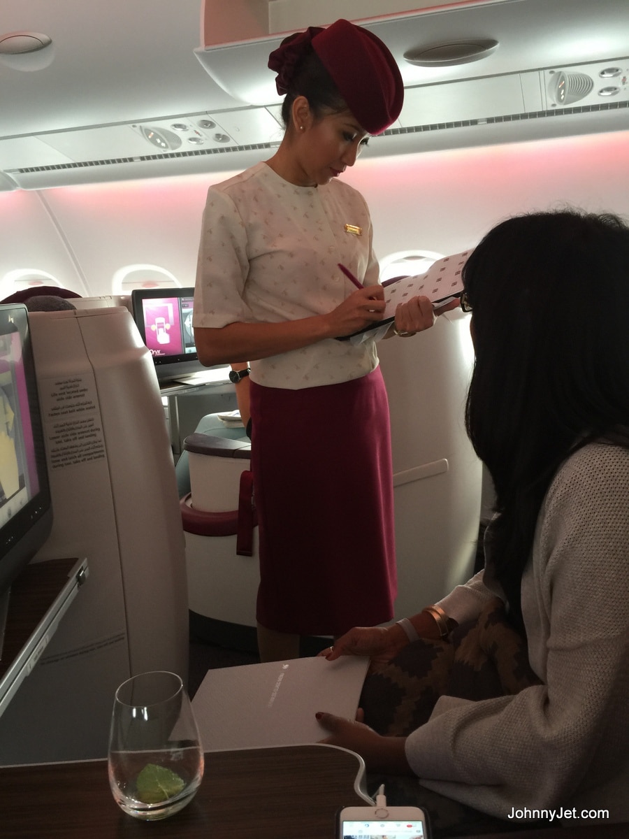 Qatar Airways flight attendant taking meal orders