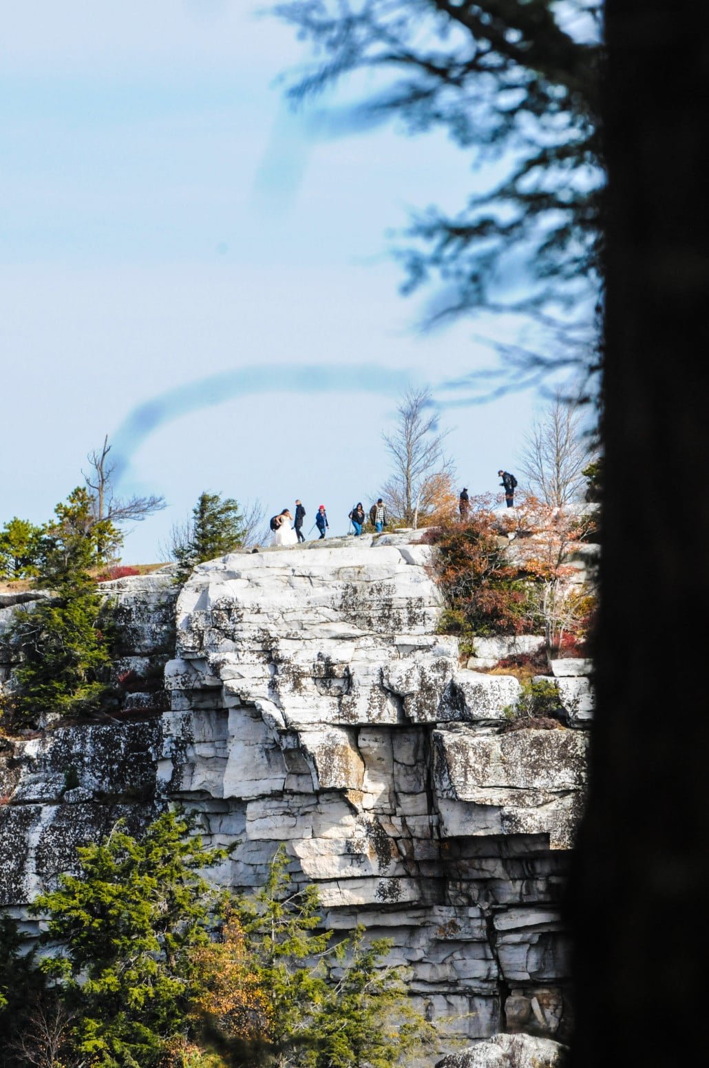 A bridal couple has their portrait taken at the top of one of the cliffs overlooking Lake Minnewaska