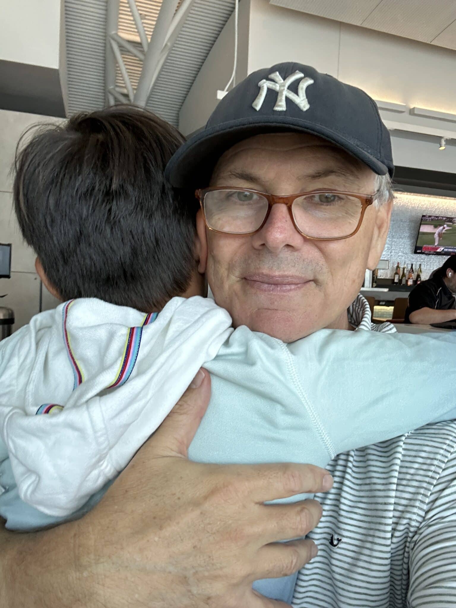 A child hugging his father in an airline lounge