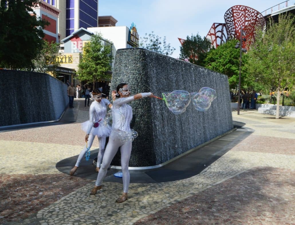 Performers in front of the water wall at the opening of The Park