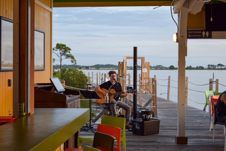 Grab a drink and an appetizer at Pelican's, a bar built in to the boardwalk extending into St. Andrews Bay