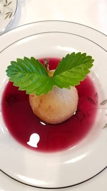 Poached pear in red wine sauce for breakfast (first course)