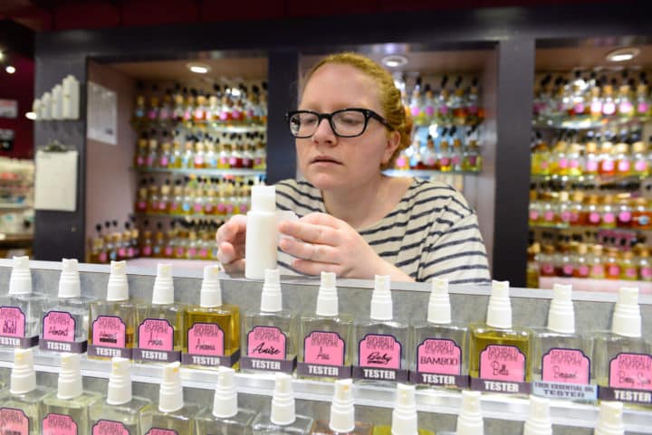 Aileen Huddleston labels a "spiced apple" lotion she just created for a customer at Archibald Sisters, a store that specializes in making its own lotions and perfumes