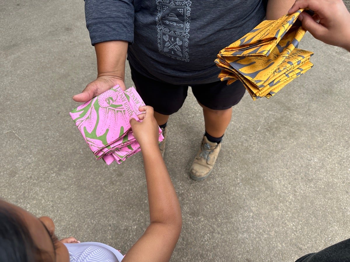 A woman at Kualoa Ranch handing out face coverings.
