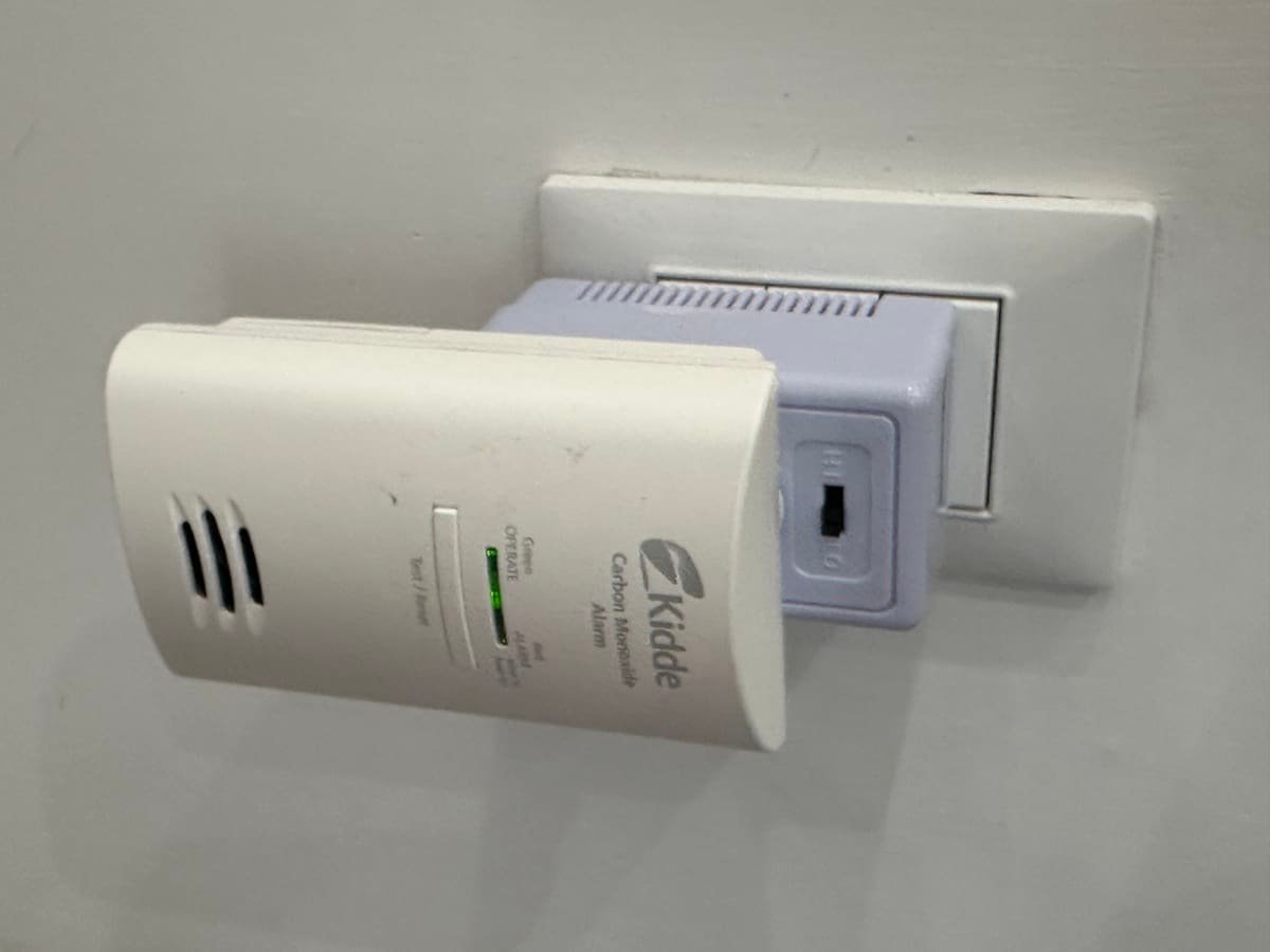 Photo of a portable carbon monoxide detector and an electrical voltage converter