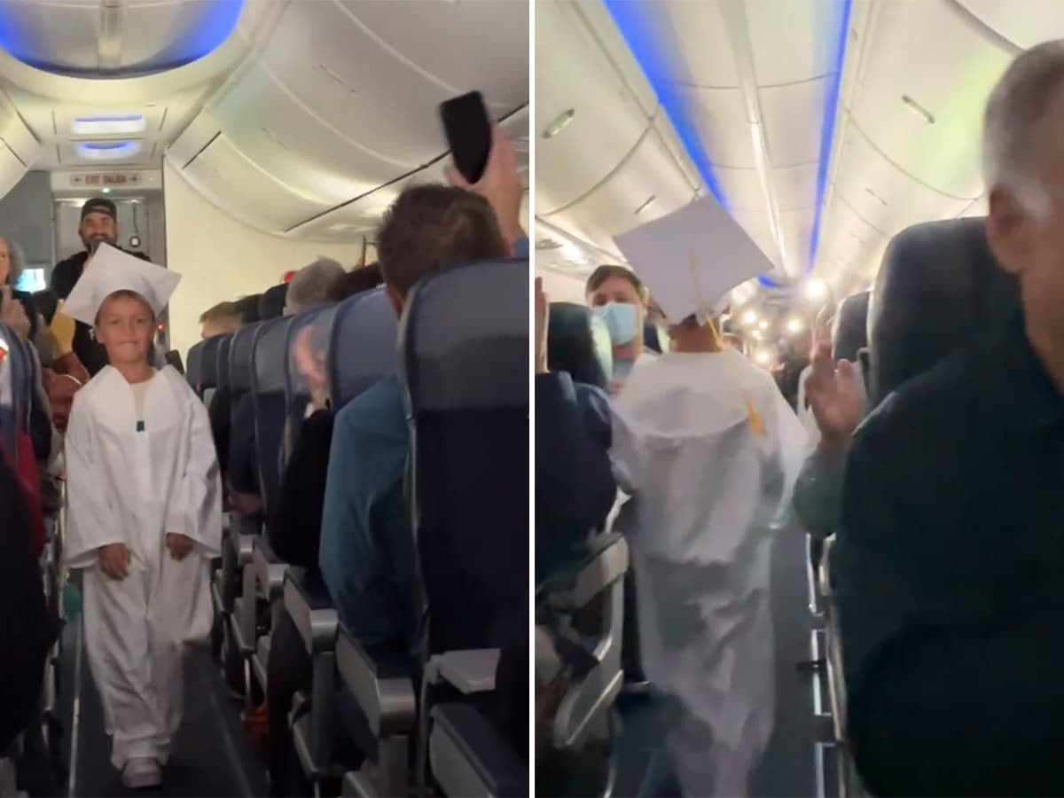 A boy walks down the aisle of a Southwest Airlines plane in a graduation cap and gown.