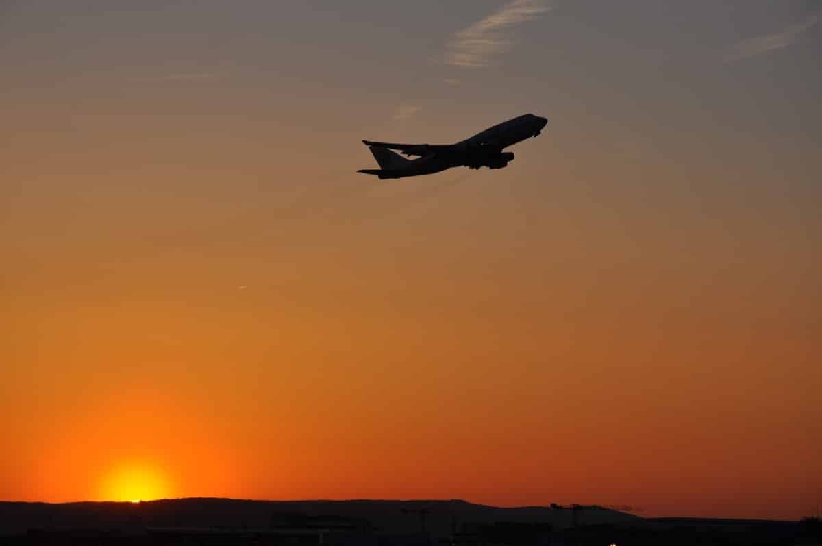 A 747 plane taking off from Frankfurt Airport with the Sun Setting