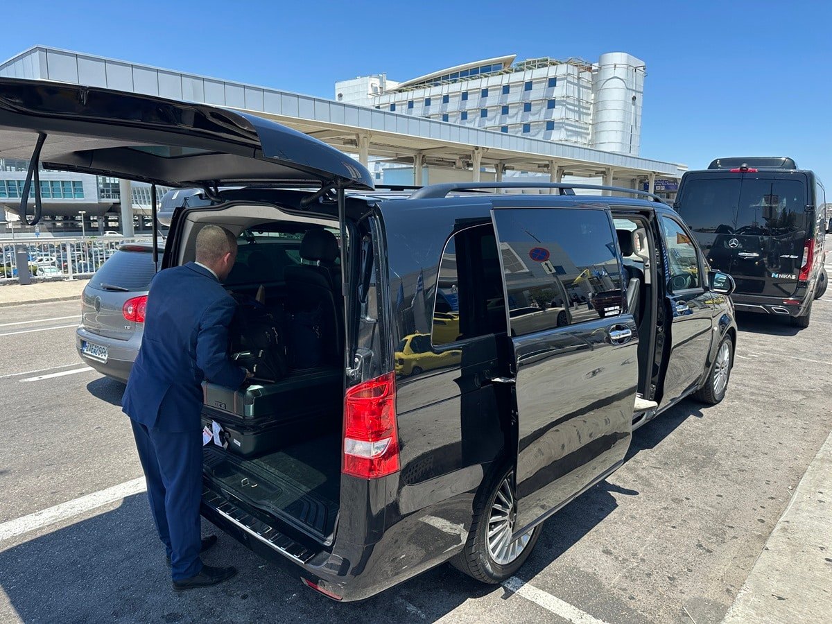 Driver getting luggage out of a van at ATH Airport