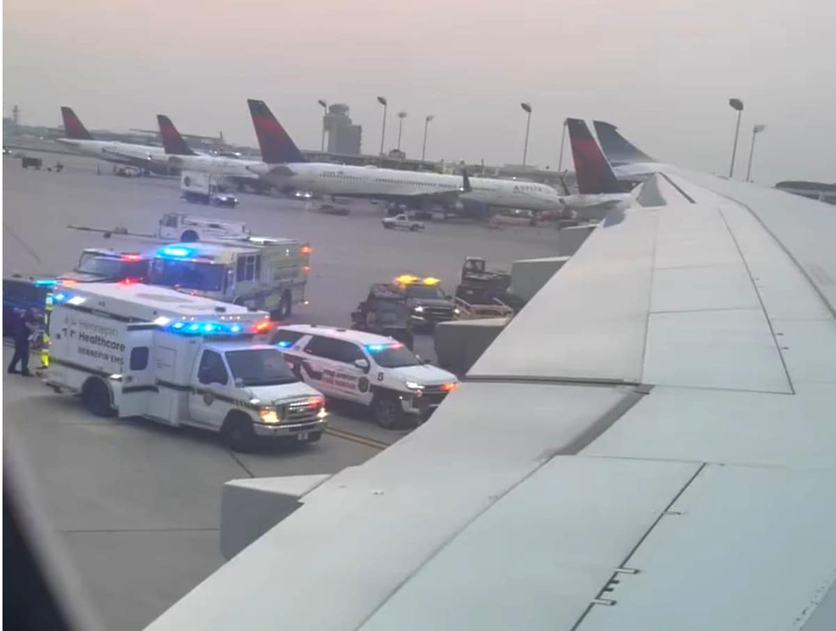 Photo taken from the plane with emergency vehicles below and other Delta planes in the background