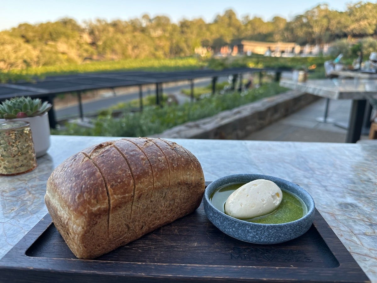 A loaf of bread with butter in duck fat overlooking a vineyard