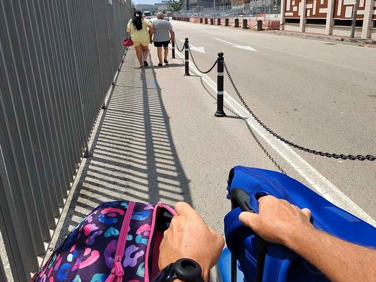 Photo of person walking with a roller bag in each hand
